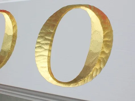 A finished carved and gilded sign ready for installation
